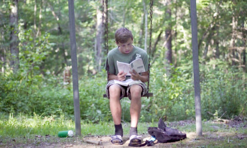 student holding a mission trip devotional