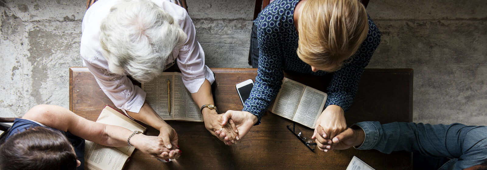 praying intergenerational group at table