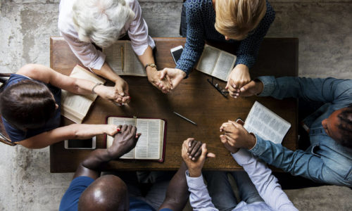 praying intergenerational group at table