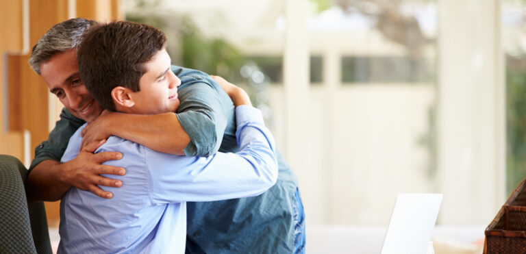 Father And Teenage Son Having A Hug